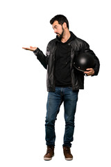 Full-length shot of Biker man holding copyspace with doubts over isolated white background