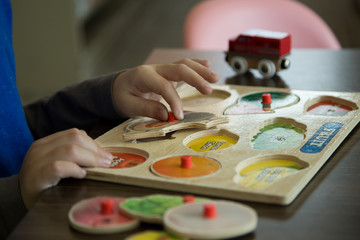 Boy playing with bright educational toys , puzzles, exploring creativity, Montessori approach