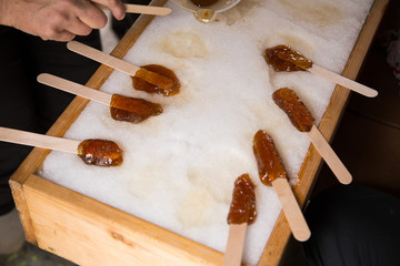 Making maple candy on snow in a maple sugar camp in New Brunswick