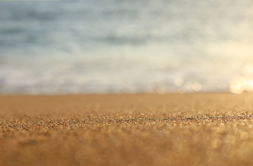 Fototapeta na wymiar background image of sandy beach and ocean waves with bright bokeh lights