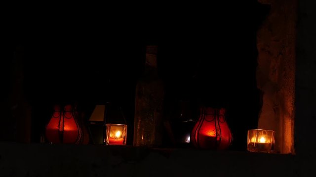 Lampen, Kerzen und Flasche in einem offenen Fenster eine alten verfallenen Bauernhauses
