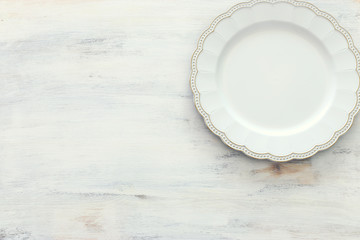 Top view of vintage white empty plate. Flat lay
