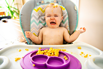 Little baby eating her dinner and making a mess
