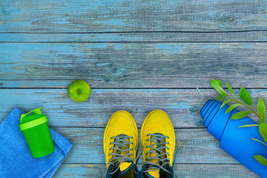 Flatlay composition of fitness equipment on a blue wooden shabby surface. Concept of healthy lifestyle, sport and activity.