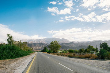 Beautiful asphalt road running through the Agaba with rocky mountains in the distance, Jordan.