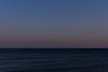 Obraz premium Quiet cozy evening at sea, purple sunset on the sea coast