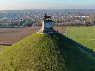 Aerial view of The Lion's Mound with farm land around.  The immense Butte Du Lion on the...
