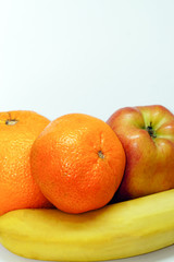 Orange mandarin banana and apple on white isolated background