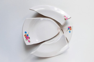 broken white plate with flowers pattern on white background