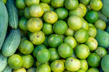 Close up fresh green limes on pile in the market.
