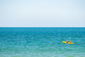 Poeple doing kayaking in the blue ocean.