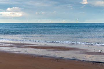 Fototapeta na wymiar Clouds over wind turbines in the North Sea, seen in Whitley Bay, Tyne And Wear, England, UK
