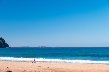 A bikini girl doing meditation and enjoying next to the ocean. Peaceful concept.