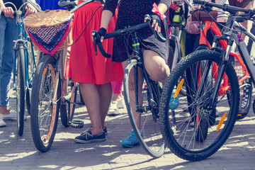 Concept: women on bicycles.  Woman in bright clothes hold the handlebars.