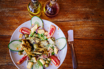 fish salad served with oil and vinegar on a rustic wooden base