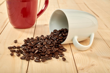 Coffee beans with coffee cup isolated on wooden table