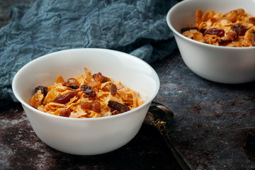 Bowl with cornflakes on a dark gray background