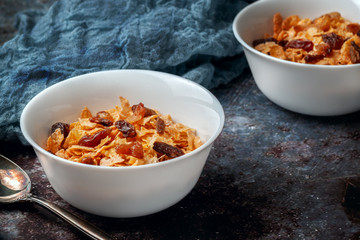 Bowl with cornflakes on a dark gray background