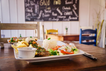 steak served in a restaurant dish with frites and rice