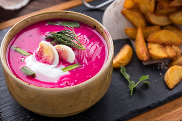 Cold beetroot soup  with egg, onion and cucumbers  garnished with fried potatoes.