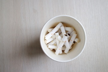 cigarette butts in a glass on the table