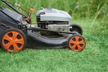 Man is using lawn mower on his countryside yard.