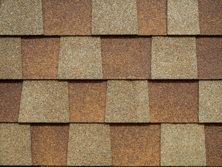 closeup of modern roof trapezoid square shingles tiles. waterproof scabrous rough surface for house exterior cover