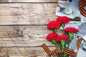 Postcard may 9 - red carnations Ribbon George Old photos on a wooden background. Symbol of victory...