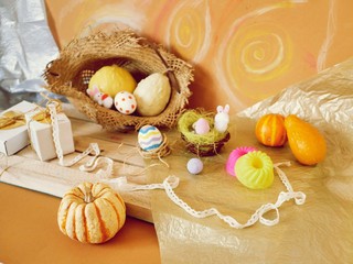 Easter decoration, painted eggs, yellow vegetables, pumpkins on a wooden light table