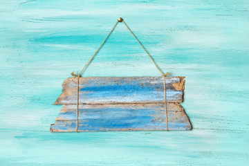 Vintage blue wooden signboard for information hanging by rope
