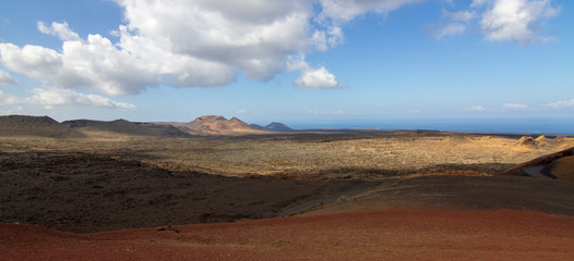 Panoramic view of Lanzarote volcanic island with blue cloudy sky