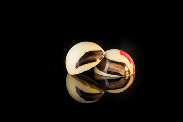 closeup two round shaped colorful chocolate candies with reflection