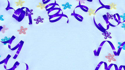 Purple ribbon and colored flowers on a white background