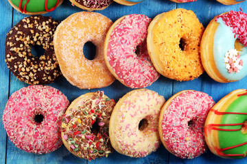 assorted donuts with chocolate frosted, pink glazed and sprinkles donuts.