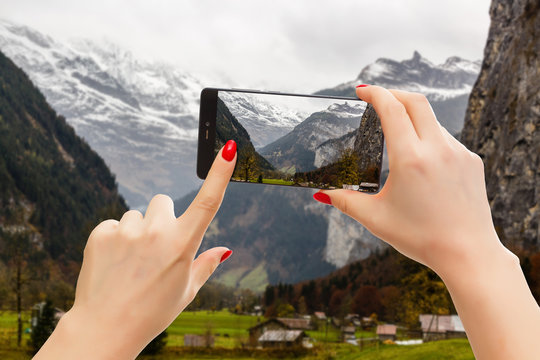 Switzerland - Beautiful medieval town on a phone, woman taking a picture of the skyline