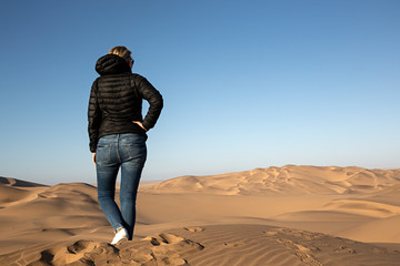 Mujer mirando el desierto de Namibia, África.