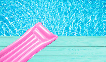 Beach summer holiday background. Inflatable air mattress on swimming pool water. Pink lilo and summertime accessories on poolside wooden floor. Top view and copy space. Banner - obrazy, fototapety, plakaty