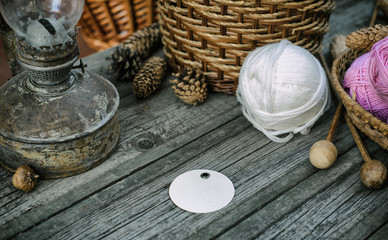 Round label on basket and ball on desk. Close up two pink balls of wool threads on wood desk