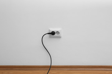 Power socket and plug on wall indoors. Electrician's equipment