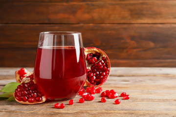 Glass of pomegranate juice and fresh fruits on table against wooden background, space for text - obrazy, fototapety, plakaty