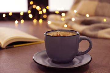Cup of hot winter drink near window. Cozy season
