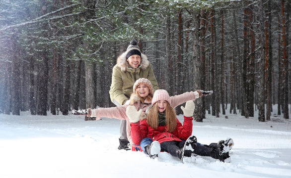 Happy Family Sledding In Forest On Snow Day