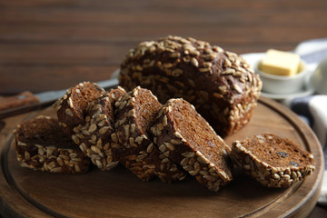 Board with tasty rye bread on table, closeup