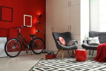 Modern living room interior with comfortable armchair, sofa and bicycle