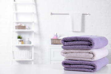 Stack of fresh towels on table in bathroom. Space for text