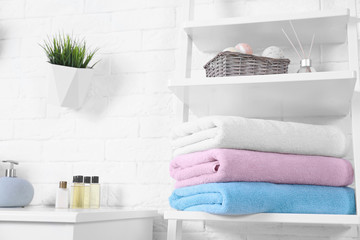 Obraz na płótnie Canvas Stack of fresh towels on shelf in bathroom. Space for text