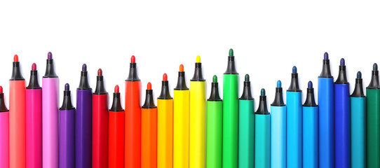Many colorful markers on white background, top view. Rainbow palette