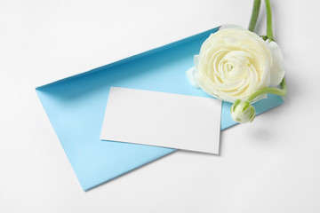 Obraz na płótnie Canvas Envelope with card and beautiful ranunculus flower on white background. Space for text