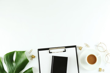 Female blog writer workspace concept. Big green monstera palm leaf on femenine desktop composition. Background, close up, copy space, flat lay, top view.