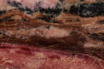 Macro stone Rhodonite mineral on a black background
